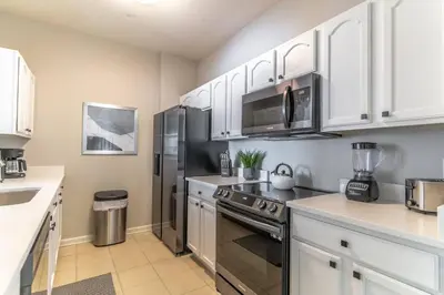 a kitchen with white cabinets and a stainless steel refrigerator at 2788 Windsor Hills in Orlando