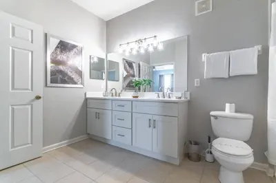 a bathroom with a toilet and a sink and a mirror at 2788 Windsor Hills in Orlando