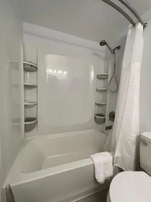 a white bathroom with a tub and a toilet at Lovely 1 bedroom Condo with pool in Orlando