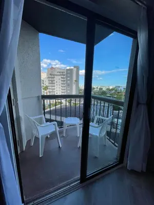 a balcony with two white chairs and a view of a city at Lovely 1 bedroom Condo with pool in Orlando