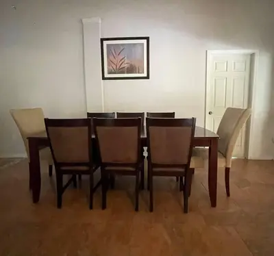 a dining room with a table and chairs and a picture at The Piano House in Orlando