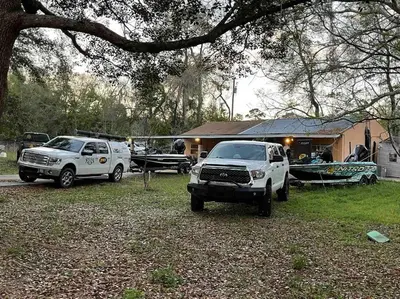 two trucks parked in a yard in front of a house at The Piano House in Orlando