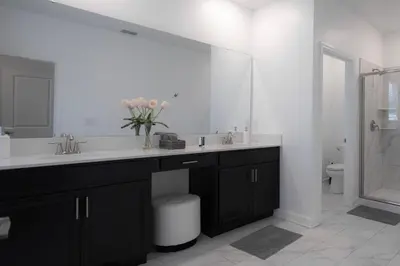 a bathroom with a sink and a large mirror at Private Vacation Home at Storey Lake, Orlando Florida in Kissimmee