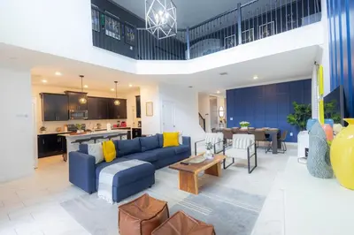 a living room with a blue couch and a kitchen at Private Vacation Home at Storey Lake, Orlando Florida in Kissimmee