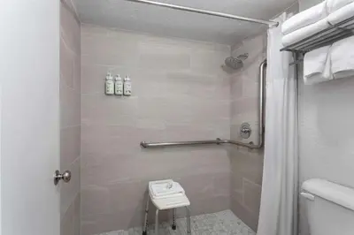 a bathroom with a shower with a toilet and a sink at Baymont by Wyndham Orlando Lake Buena Vista South in Kissimmee