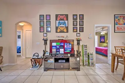 a living room with a flat screen tv on a wall at 10 Mi to Disney and Heated Pool Florida Abode! in Orlando