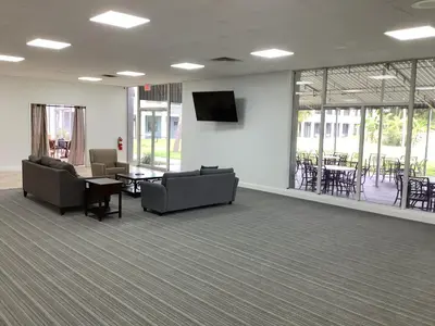 a waiting room with couches and a table and chairs at Heritage Park Inn in Kissimmee