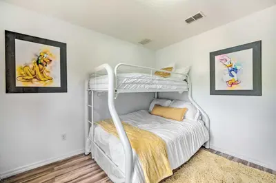 a bedroom with a bunk bed and two pictures on the wall at Kissimmee Condo Community Perks, 10 Mi to Disney! in Kissimmee