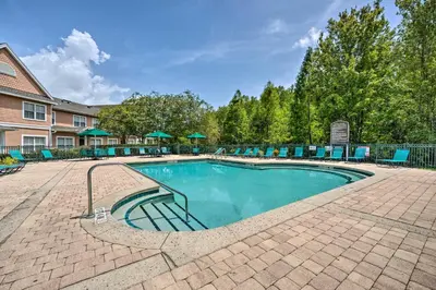 a swimming pool with blue chairs around it at Kissimmee Condo Community Perks, 10 Mi to Disney! in Kissimmee