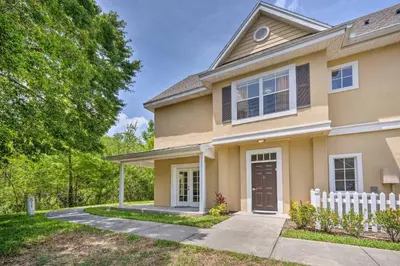 a house with a white fence in front of it at Kissimmee Condo Community Perks, 10 Mi to Disney! in Kissimmee