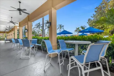 a patio with blue chairs and tables and umbrellas at 3 Bedrooms 25 Bathrooms Encantada 3091 Yl in Orlando