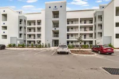 a parking lot in front of a large apartment building at 2 Bedrooms 2 Bathrooms Storey Lake 3150-404 Pc in Kissimmee