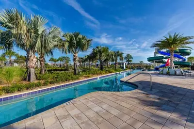 a swimming pool with palm trees and a slide at 2 Bedrooms 2 Bathrooms Storey Lake 3150-404 Pc in Kissimmee