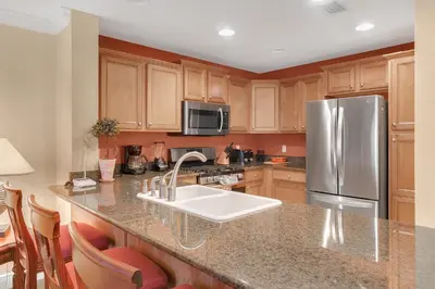a kitchen with a sink and a stainless steel refrigerator at 3 Bedrooms 25 Bathrooms Reunion Resort 1589 Hc in Orlando