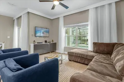 a living room with a couch and blue chairs at 4 Bedrooms 3 Bathrooms Storey Lake 3195 Pp in Orlando
