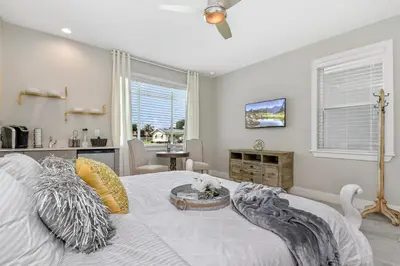 a bedroom with a white bed and a living room at Centrally Located Guest Suite Retreat in Orlando