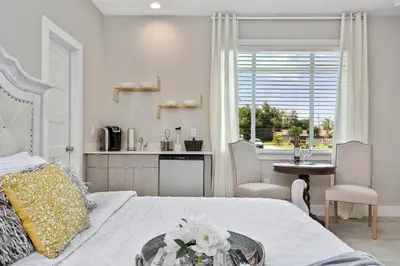 a bedroom with a bed and a table and a kitchen at Centrally Located Guest Suite Retreat in Orlando