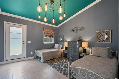 a bedroom with two beds and a dresser and a window at 5Bd 4Bath villa, amazing outdoor space, pet friendly in Orlando