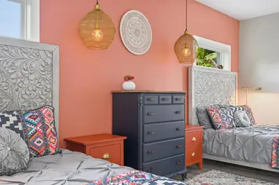 a room with a bedroom with a dresser and a bed at Bohemian Retreat in the Heart of Orlando in Orlando