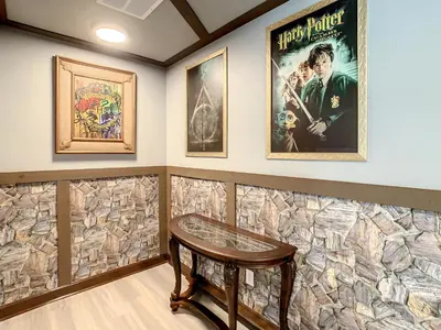 a room with a stone wall with a table and posters at Marvelous Magical House: Amazing Themes and Pool, 5mi Disney in Kissimmee