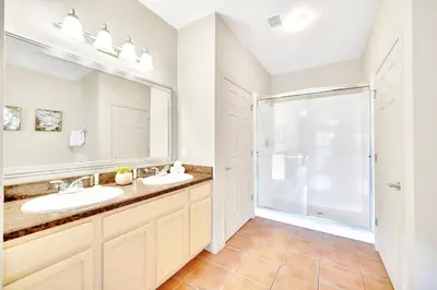 a bathroom with two sinks and a large mirror at 3BR Condo with Pool Close to Disney in Orlando