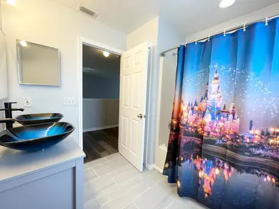 a bathroom with a disneyland shower curtain at Fully Renovated, Quiet, Spacious Disney Themed Pool Home with Office in Kissimmee