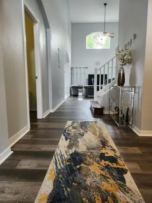 a living room with a rug on the floor at Fully Renovated, Quiet, Spacious Disney Themed Pool Home with Office in Kissimmee