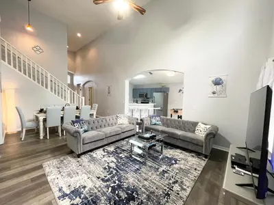 a living room with two couches and a tv at Fully Renovated, Quiet, Spacious Disney Themed Pool Home with Office in Kissimmee