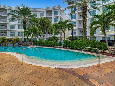 a swimming pool in front of a building with palm trees at Pet Friendly in Orlando area near Disney in Orlando