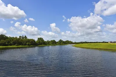 a river under a blue sky with clouds at Lakeside 4-Bed Pool Home at Villa Sol home in Kissimmee