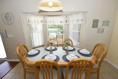 a dining room with a table and chairs at Lakeside 4-Bed Pool Home at Villa Sol home in Kissimmee