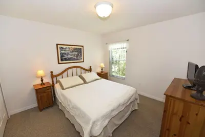a bedroom with a bed and a television and a window at Lakeside 4-Bed Pool Home at Villa Sol home in Kissimmee