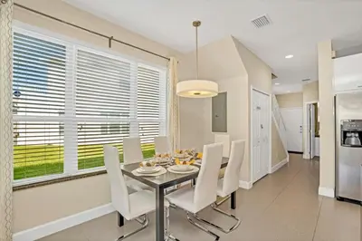 a dining room with a table and white chairs at 1511RETREAT townhouse in Orlando