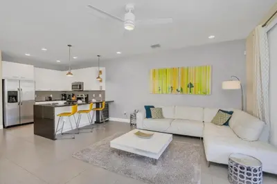 a living room with a white couch and a kitchen at 1511RETREAT townhouse in Orlando