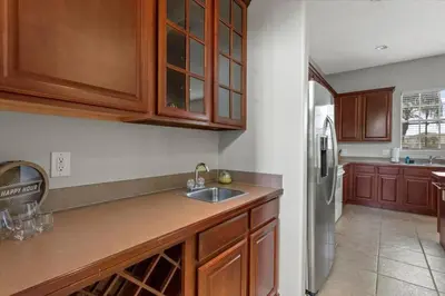 a kitchen with wooden cabinets and a sink at LONG STAYS! Lakefront - Gated Pool Home in Orlando