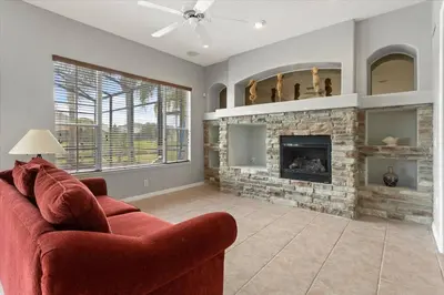 a living room with a red couch and a fireplace at LONG STAYS! Lakefront - Gated Pool Home in Orlando