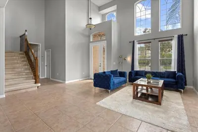 a living room with a blue couch and a table at LONG STAYS! Lakefront - Gated Pool Home in Orlando