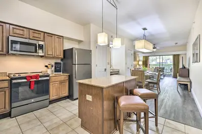 a kitchen with wooden cabinets and stainless steel appliances at Disney Good Neighbor Resort Condo Less Than 4 Mi to WDW! in Orlando