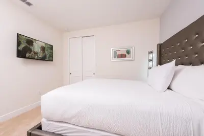 a white bedroom with a large bed with white sheets at Alluring Home With Private Pool Near Disney With Waterpark Resort Access At Encore Resort - 7732Ff in Kissimmee