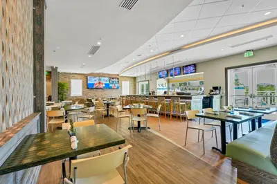 a restaurant with tables and chairs and a bar at Alluring Home With Private Pool Near Disney With Waterpark Resort Access At Encore Resort - 7732Ff in Kissimmee