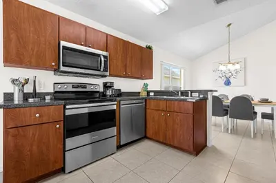 a kitchen with a stove and a microwave at Disney Area 4BR Home with Heated Private Pool in Kissimmee