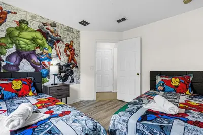 a bedroom with two beds and a marvel mural at Disney Area 4BR Home with Heated Private Pool in Kissimmee
