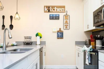 a kitchen with white cabinets and a sink at Magnificent 5Bd w/ Pool Close to Disney @Storey Lake 4800 in Kissimmee