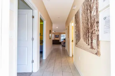 a hallway of a home with a painting on the wall at Magnificent 5Bd w/ Pool Close to Disney @Storey Lake 4800 in Kissimmee