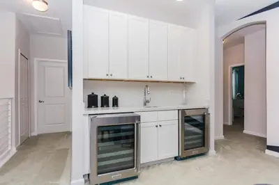 a kitchen with white cabinets and a sink at Magical Retreat: Luxurious Home near Disney World in Kissimmee