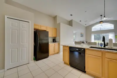 a kitchen with a black refrigerator and a sink at Kissimmee Getaway with Pool about 7 Mi to Disney! in Kissimmee