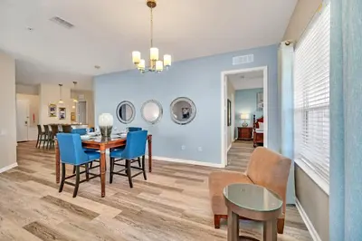 a dining room and living room with a table and chairs at Lakeview Condo Directly Next To Pool Near WDW in Orlando