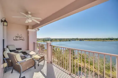 a balcony with chairs and a view of the water at Lakeview Condo Directly Next To Pool Near WDW in Orlando