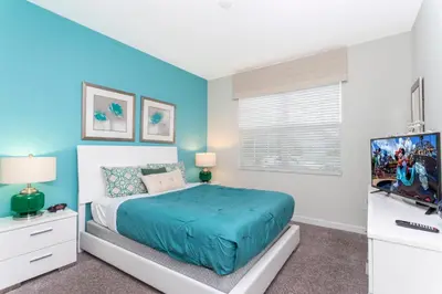 a bedroom with a bed and a flat screen tv at Blue Moon House in Kissimmee