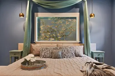 a bedroom with a bed with a painting on the wall at Best Location Pet Friendly Fenced Yard in Orlando